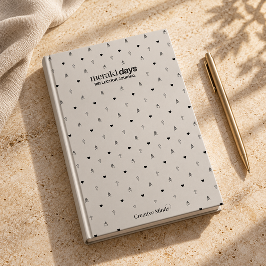 Meraki Days Reflection Journal with grey patterned cover, styled beside a brass pen on warm stone.